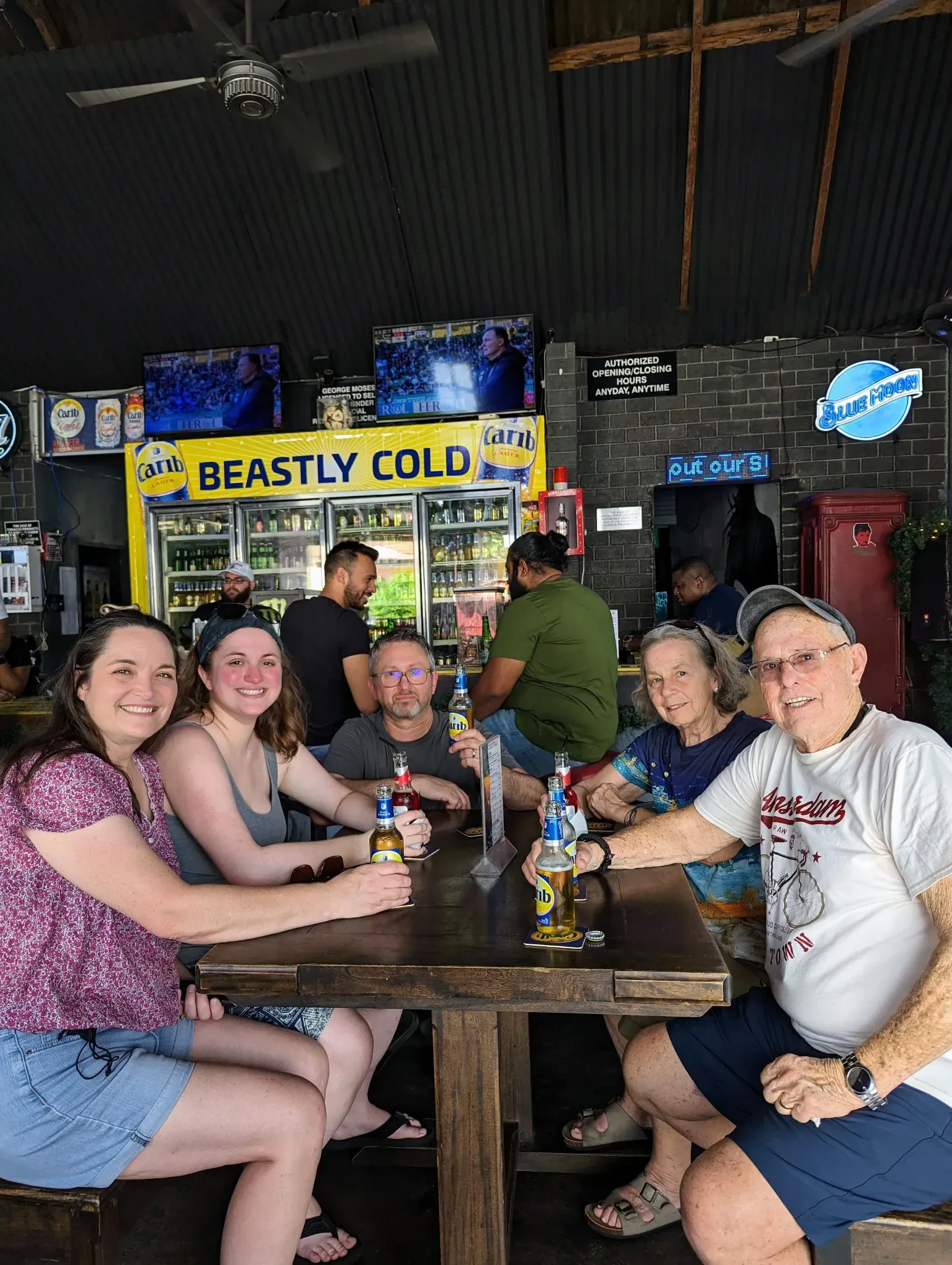 A group of guests seated together with drinks at a bar stop.