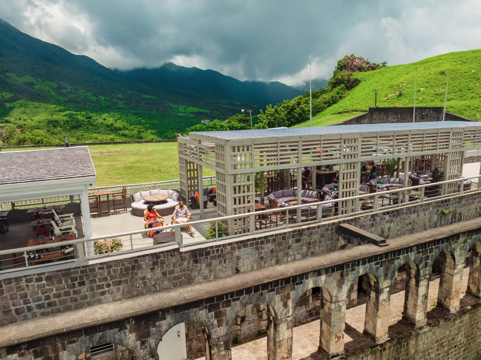 Gibraltar Gastrolounge’s open terrace above stone arches, with Brimstone Hill’s green landscape beyond.