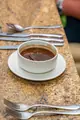 A white bowl of rich broth served on the dining table during the Carambola food tour.